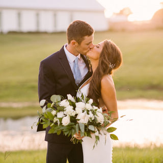 Portrait of bride and groom holding an elegant bouquet after the wedding.