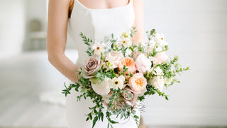 Elegant bride holding fresh wedding bouquet arranged by wedding florist Bride and Bloom Florals for an elegant wedding.