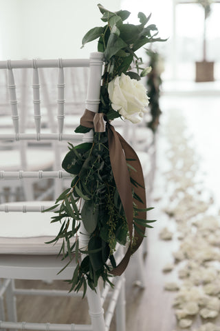 Floral pew marker decor in wedding venue.