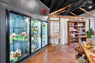 Inside Bride and Bloom shop showing the cooler filled with flower arrangements ready for pickup.