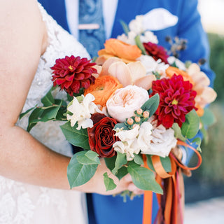 Vibrant bridal bouquet held by the bride and groom.