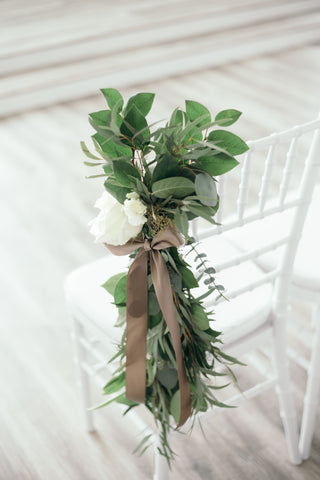 White flower and greenery as aisle floral pew marker.
